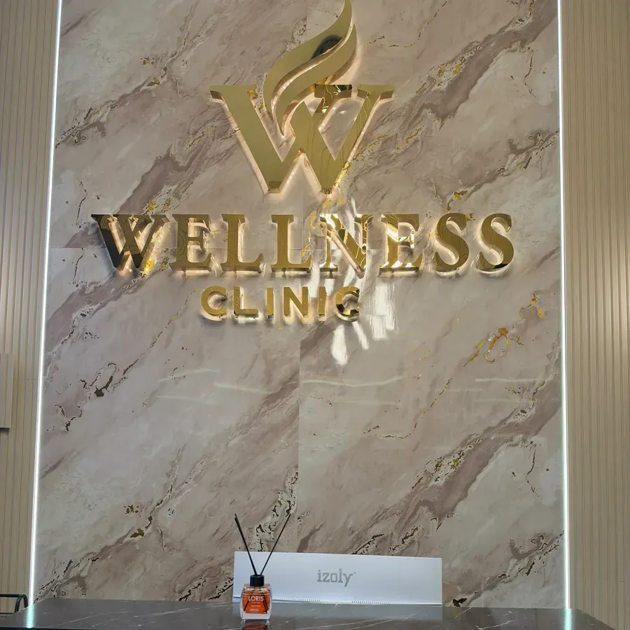 Wellness Beauty Denizli şubesi resepsiyon alanı ve altın renkli logo duvarı